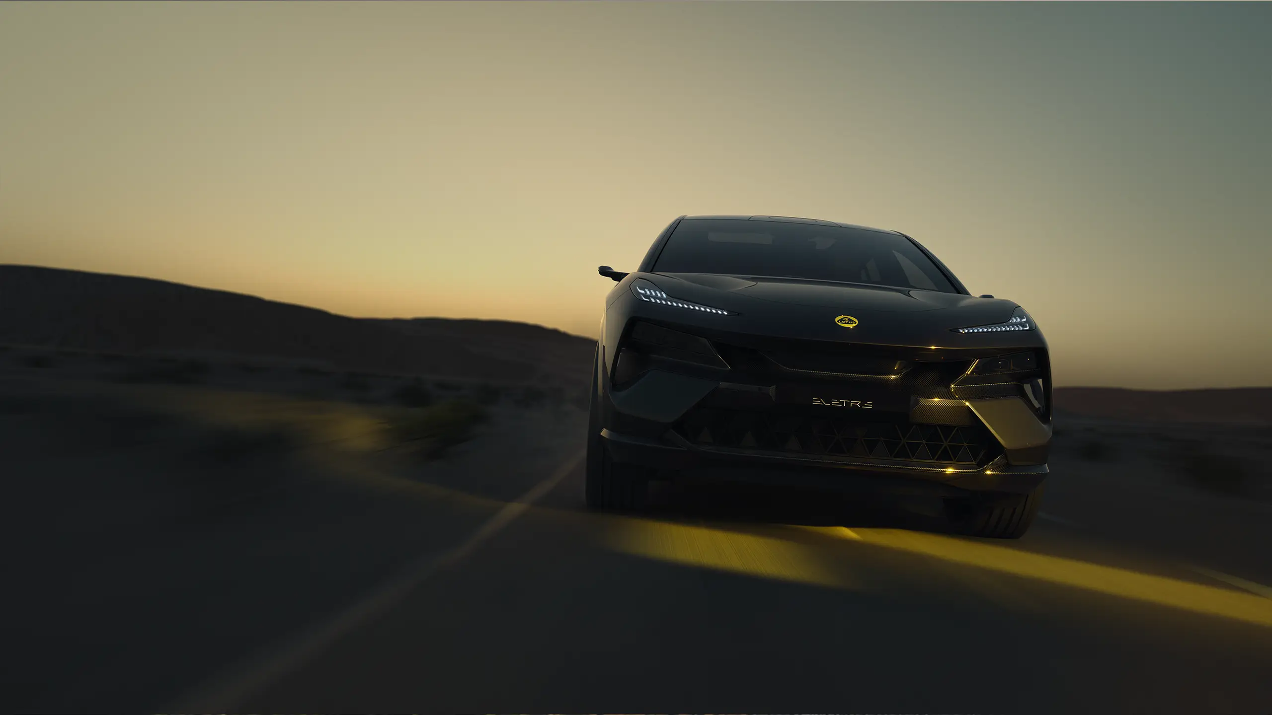 Lotus Eletre approaching on a road at sunset