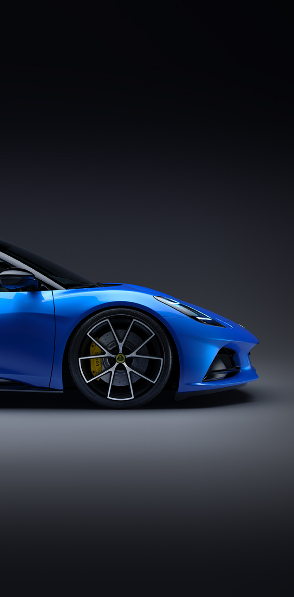 Front proflie of the forward half of a blue Lotus Emira in an abstract grey environment. The yellow brake calipers and yellow Lotus wheel badge are visible. | 0702M-图集1.jpg